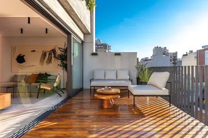 Terraza moderna con deck de madera y vista urbana — proyecto Depto Valle, por Ayelen Mayer Arquitectura, en Buenos Aires
