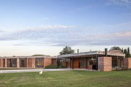 fachada de casa moderna de ladrillos y hormigón en entorno rural — proyecto Casa Volt, por Estudio PK, en Capilla del Señor