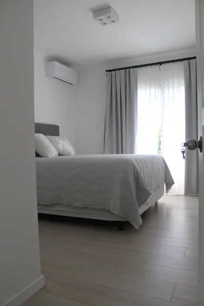 Dormitorio moderno con cama queen y cortinas grises y blancas — proyecto CASA LA LOMADA , por Estudio Grupo 32, en Pilar