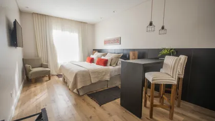 Dormitorio moderno estilo hotel con iluminación cálida — proyecto Villa Isidro Hotel Boutique & Spa, por Hermann Arquitectos, en San Isidro