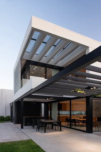 Casa moderna con pérgola y ventanales amplios — proyecto CASA SD28, por GMARQ, en Buenos Aires