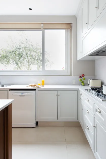 Cocina blanca moderna con ventana grande y electrodomésticos integrados — proyecto Casa MF, por Estudio Junor, en Belén de Escobar