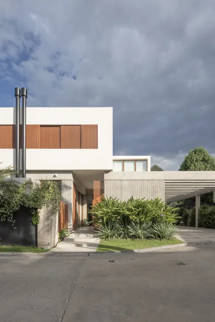 fachada moderna con concreto, madera y vegetación — proyecto CASA OrAz, por Alfredo Orfila arquitectura, en San Isidro