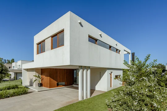 Casa moderna blanca con detalles en madera y grandes ventanales — proyecto Casa Estudio GR, por MUCHTEK, en City Bell