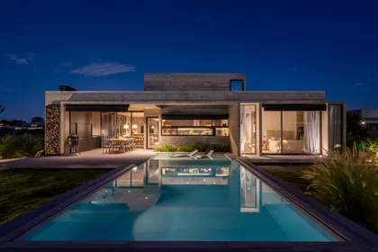 Casa moderna con piscina iluminada por la noche — proyecto Casa Tres Patios, por Besonías Almeida arquitectos, en Pilar
