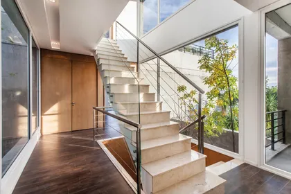 Escalera moderna con doble altura, vidrios y planta colgante interior — proyecto Racionalismo en Hormigón, por Ciba Arquitectura
