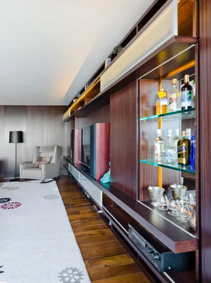 Sala de estar moderna con mueble de madera empotrado — proyecto Departamento Nuñez, por Claudia Faena Studio, en Núñez