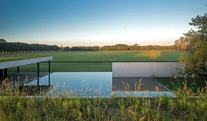 piscina moderna con campo verde al atardecer — proyecto Figueras Polo Stables, por Estudio Ramos, en General Rodríguez