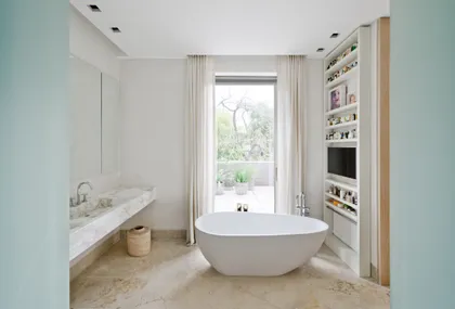 Baño moderno con bañera exenta y gran ventana — proyecto Casa H, por Estudio Dado, en Belgrano