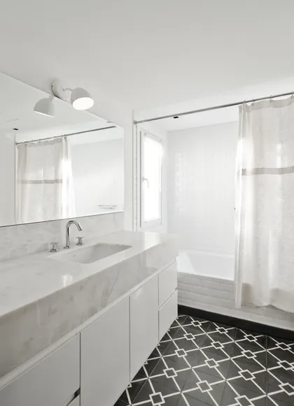 Baño moderno con suelo de mosaico geométrico, muebles blancos y mármol — proyecto Casa BA, por Estudio Dado, en Pilar