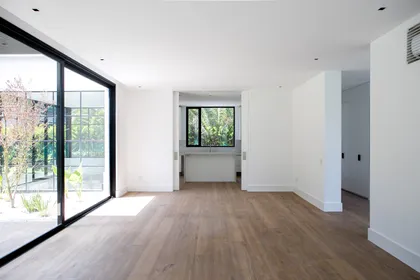 Living room de diseño moderno con grandes ventanales y pisos de madera — proyecto Bosque Chico, por Estudio Arq. María Sioli, en Garin