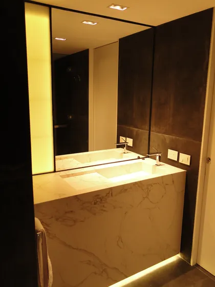 Baño moderno con tocador doble, iluminación integrada y revestimiento de mármol — proyecto Beruti I, por Karen Garber Arquitecta, en Palermo