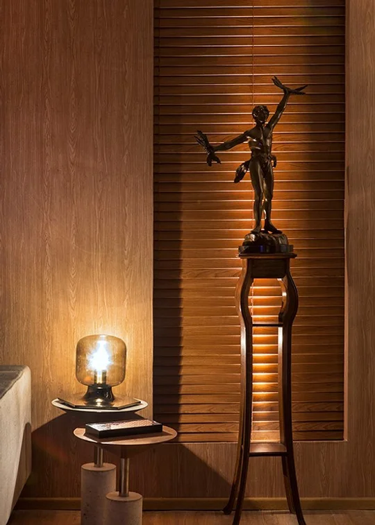 Pasillo con pared madera, escultura en pedestal y lámpara cálida — proyecto Casa COR Pernambuco 2014 - Loft, por André Caricio