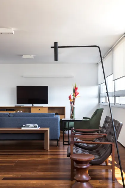 Amplio living comedor con sillones mid-century y lámpara de pie negra — proyecto Apartamento JB, por Boscardin Corsi Arquitetura
