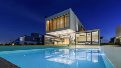 casa moderna con piscina iluminada de noche — proyecto VIRAZON 201, por BARRIONUEVO VILLANUEVA ARQUITECTOS