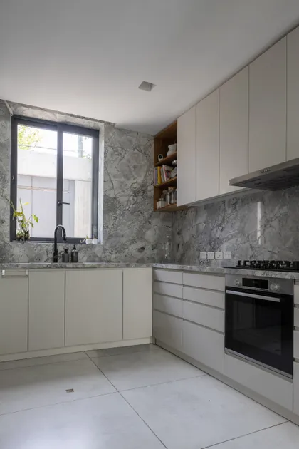 Cocina moderna con paredes de mármol y muebles blancos — proyecto CASA OrBa, por Alfredo Orfila arquitectura, en San Isidro