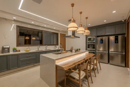 Cocina moderna con isla, mesadas de madera y acero inoxidable — proyecto Projeto Destaque Club&Casa, por Andrea Carvalho Arquitetura