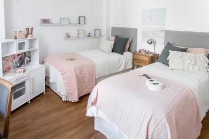 Dormitorio minimalista con dos camas, paredes blancas y suelo de madera — proyecto Las Heras , por Claraboia , en Recoleta
