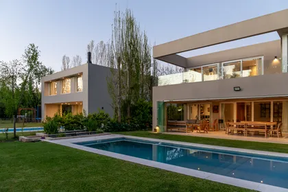 Fachada moderna con piscina e integración de madera — proyecto Campo grande III, por Juarez-Fevre Estudio de Arquitectura , en Buenos Aires
