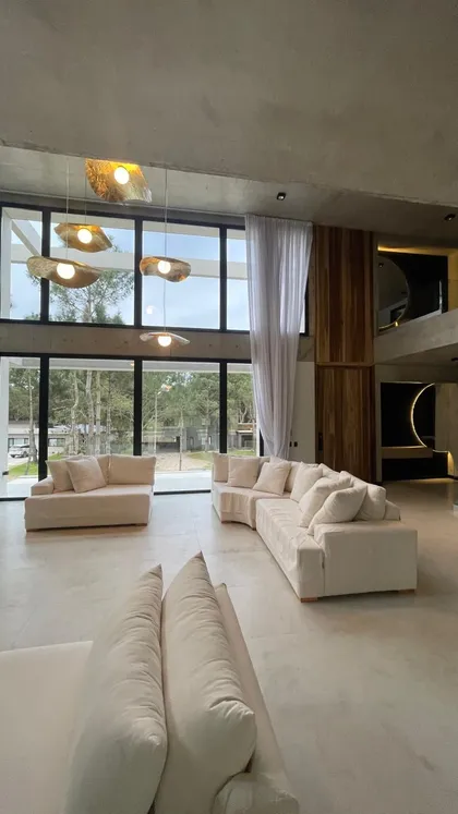 Living moderno con ventanales y luces orgánicas — proyecto Pinamar, por Perfecta Iluminación, en Pinamar