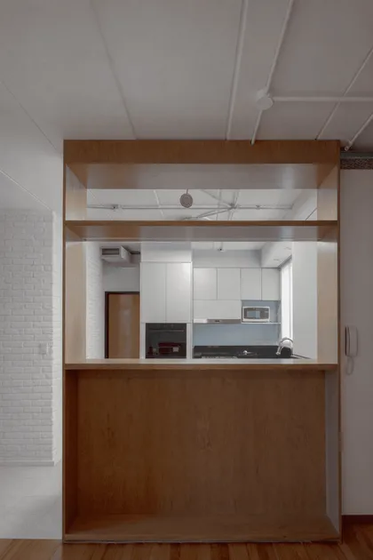 Cocina moderna con isla divisoria de madera y pared de ladrillo visto — proyecto Reforma 11 de septiembre, por Estudio YME, en Núñez
