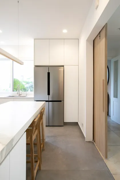 Cocina moderna con isla, suelo de hormigón y electrodomésticos de acero inoxidable — proyecto Obra Newman FH, por Arq. Lourdes Yarade Saravia, en Benavidez