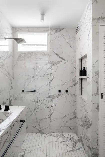 Baño moderno con mármol, ducha de cristal y grifería negra — proyecto Alvear | Redefining luxury, por Ren Studio, en Recoleta
