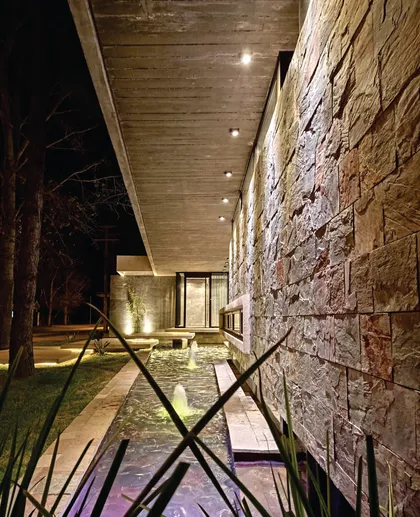 fachada de piedra moderna con piscina y hormigón expuesto — proyecto CASA EG, por C&R ARQUITECTURA + PAISAJISMO, en San Jorge