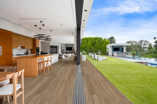 Cocina moderna de planta abierta con isla, acceso a patio exterior y pileta — proyecto 20x120, por Cerámica Alberdi 