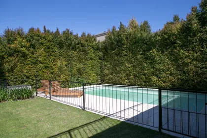 Pileta con deck y cerco de madera en jardín con árboles — proyecto Ayres Plaza, por ATO Arquitectos, en Ayres Plaza