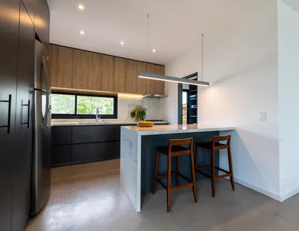 Cocina moderna con isla de mármol y madera natural — proyecto Santa Isabel - Andrea Gonzalez, por ABEJA CONCEPT, en Nordelta