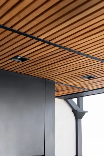 Techo de madera a listones con luces empotradas, fachada negra y blanca — proyecto Casa en Martinez, por JT ARQUITECTURA, en Martínez
