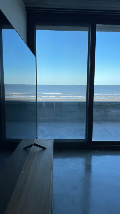 Sala minimalista con vista al mar y ventanales — proyecto CASA sobre el MAR, por Guerrero Arquitectos, en Pinamar