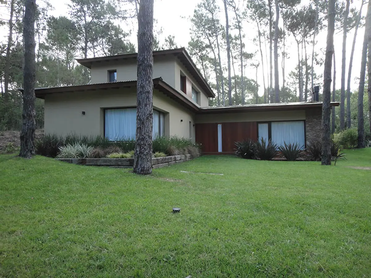 Fachada moderna em floresta com janelas grandes — projeto Casa Cariló 2015, por Hugo Zawadski Arquitectos, em Cariló