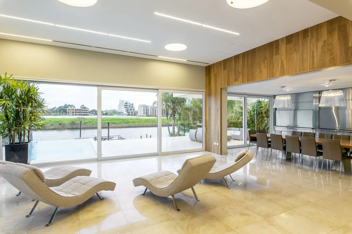 Sala moderna com vista para piscina e detalhes em madeira — projeto Las Caletas, por Arfuso Arquitectos, em Nordelta