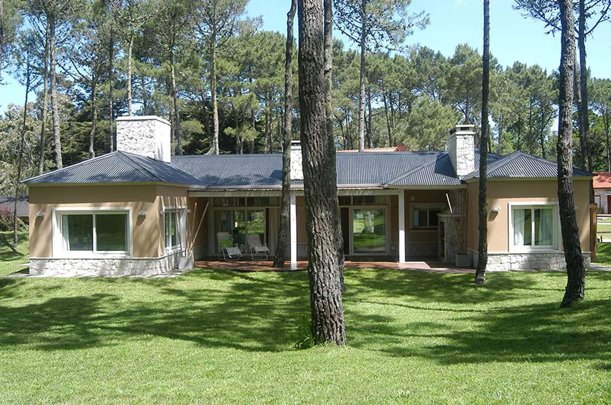 Fachada de casa residencial moderna em meio a floresta — projeto Casa Cariló 2005, por Hugo Zawadski Arquitectos, em Cariló