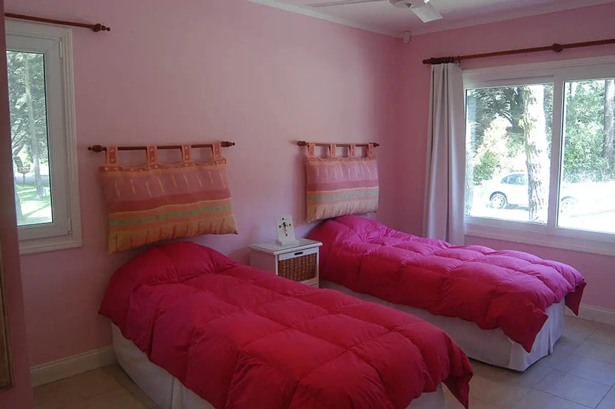 Quarto juvenil com duas camas e detalhes em rosa — projeto Casa Cariló 2005, por Hugo Zawadski Arquitectos, em Cariló