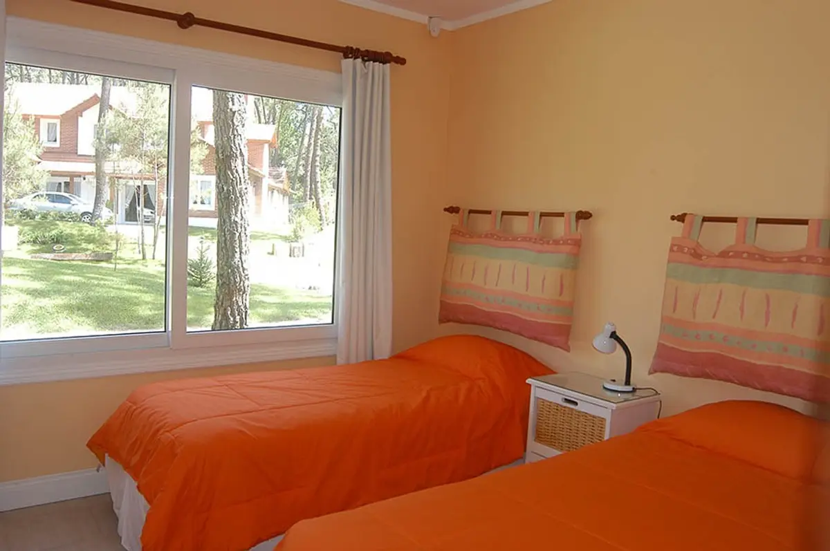 Quarto moderno com camas laranjas e janelas amplas — projeto Casa Cariló 2005, por Hugo Zawadski Arquitectos, em Cariló