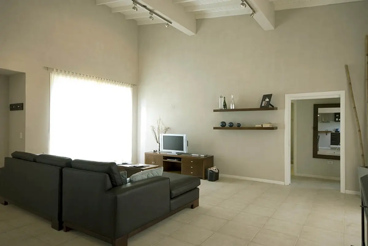 Sala moderna com pé-direito duplo e vigas expostas — projeto Casa Cariló 2007, por Hugo Zawadski Arquitectos, em Cariló