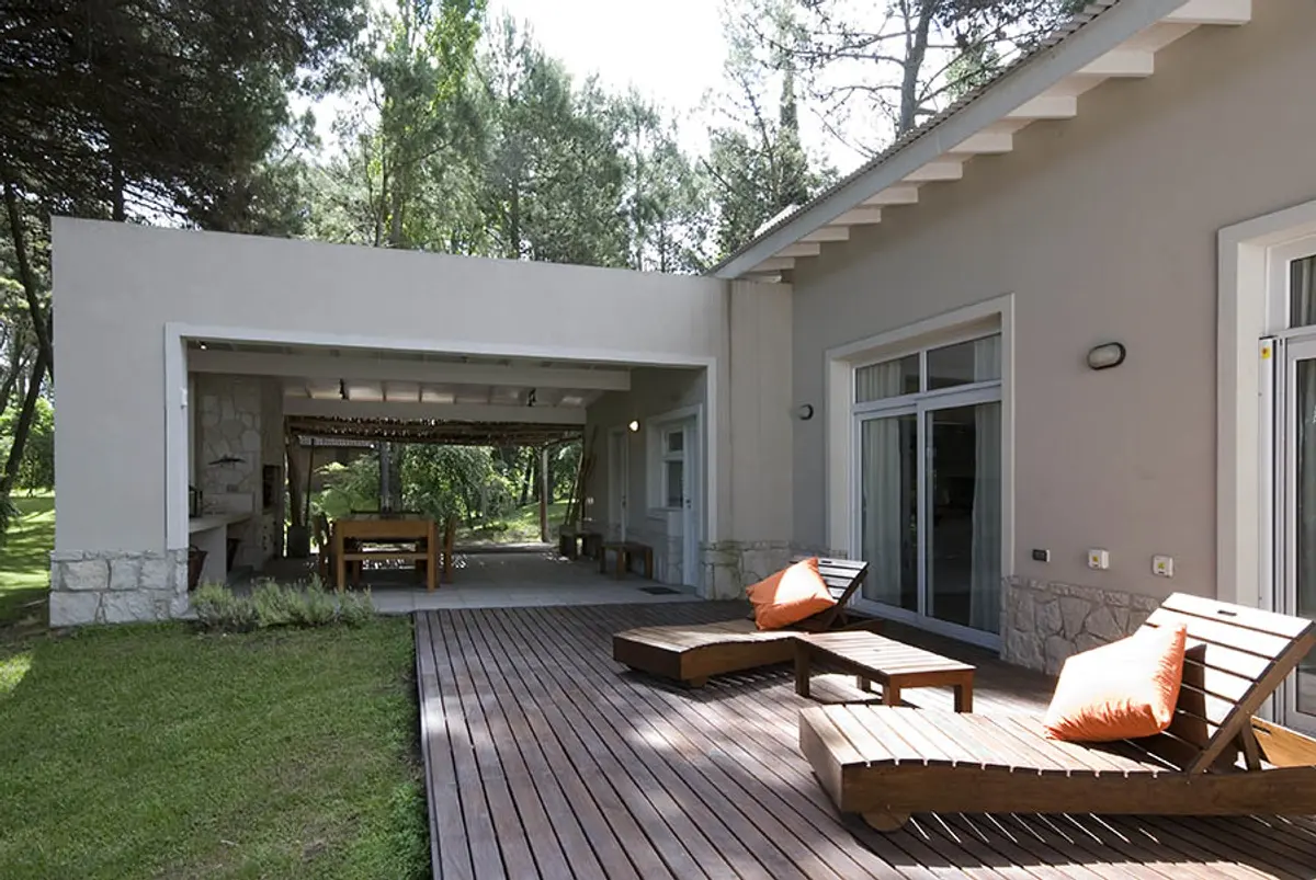 Pátio moderno com deck de madeira e vegetação exuberante — projeto Casa Cariló 2007, por Hugo Zawadski Arquitectos, em Cariló