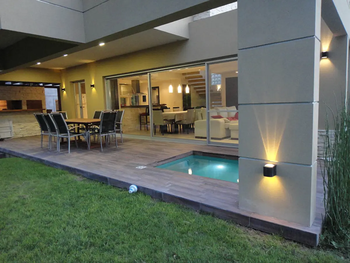 Patio moderno con piscina integrada y deck de madera — proyecto Casa Valeria del Mar 2015, por Hugo Zawadski Arquitectos, en Valeria del Mar
