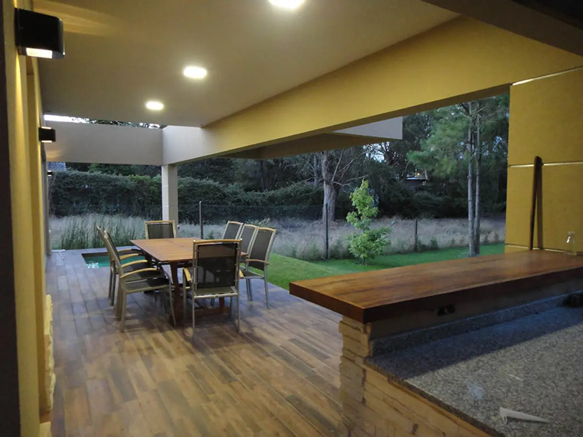 Terraza con deck de madera y mesa de comedor moderna — proyecto Casa Valeria del Mar 2015, por Hugo Zawadski Arquitectos, en Valeria del Mar