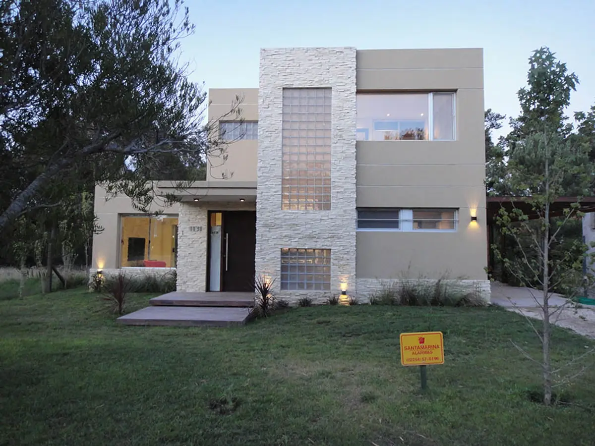 casa moderna con frente de piedra blanca y hormigón beige — proyecto Casa Valeria del Mar 2015, por Hugo Zawadski Arquitectos, en Valeria del Mar