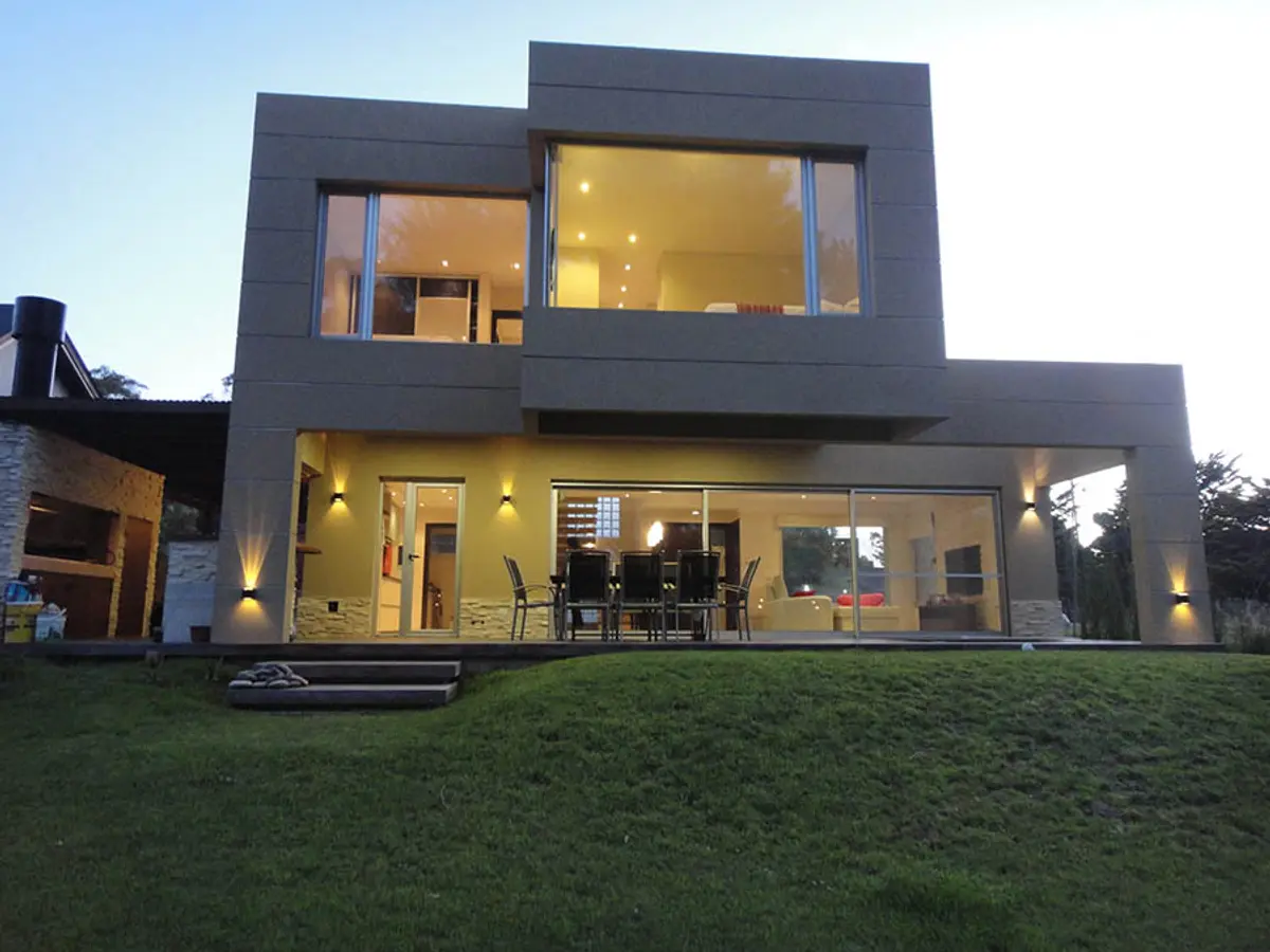 Fachada moderna de casa com grandes janelas e concreto — projeto Casa Valeria del Mar 2015, por Hugo Zawadski Arquitectos, em Valeria del Mar