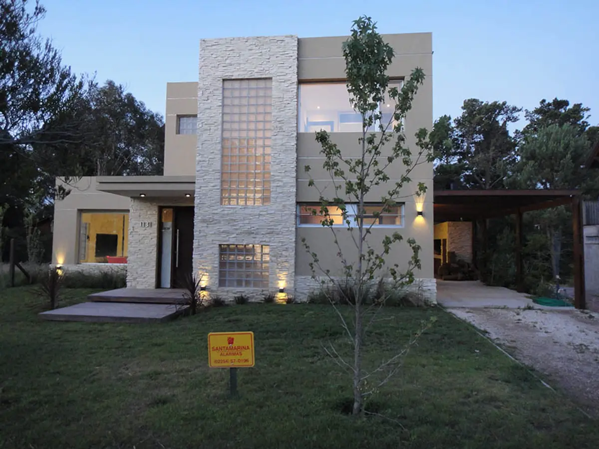 Fachada moderna de casa com blocos de vidro e janelas amplas — projeto Casa Valeria del Mar 2015, por Hugo Zawadski Arquitectos, em Valeria del Mar