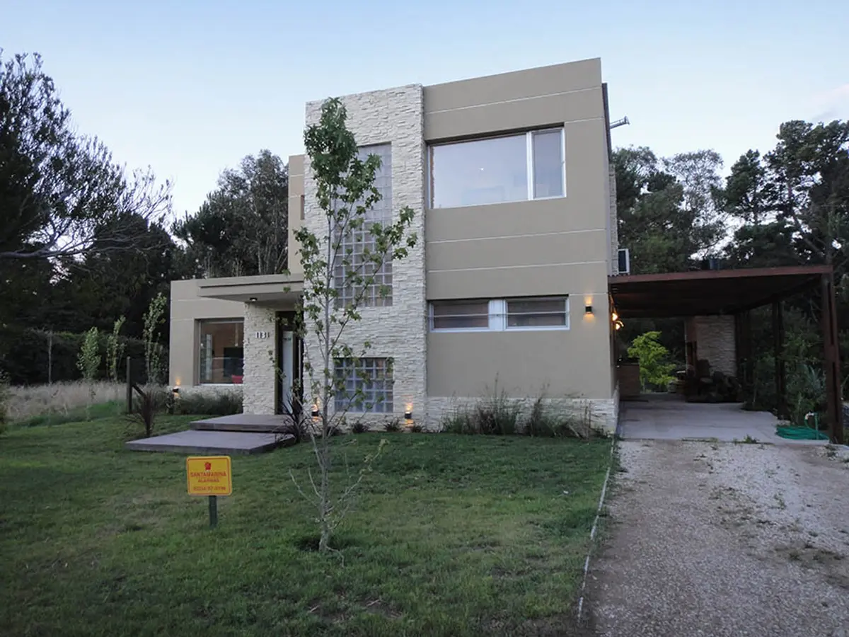 Fachada moderna com pedra e pergolado em área suburbana — projeto Casa Valeria del Mar 2015, por Hugo Zawadski Arquitectos, em Valeria del Mar