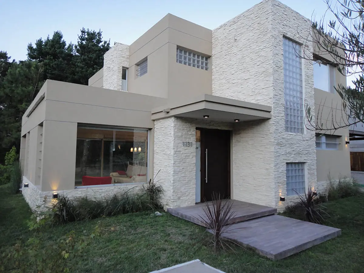 Casa moderna con volúmenes geométricos y fachada de piedra — proyecto Casa Valeria del Mar 2015, por Hugo Zawadski Arquitectos, en Valeria del Mar
