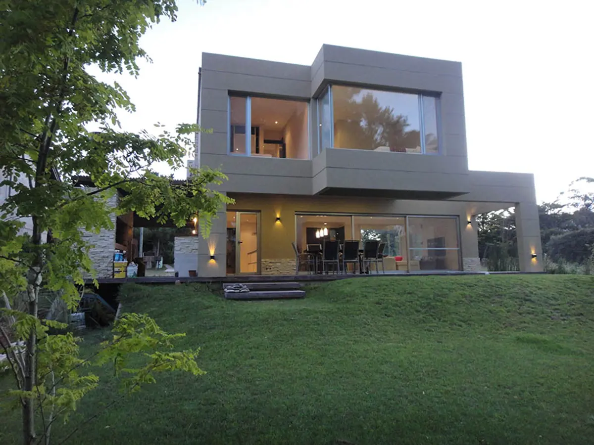 Casa moderna con fachada de hormigón y grandes ventanales — proyecto Casa Valeria del Mar 2015, por Hugo Zawadski Arquitectos, en Valeria del Mar