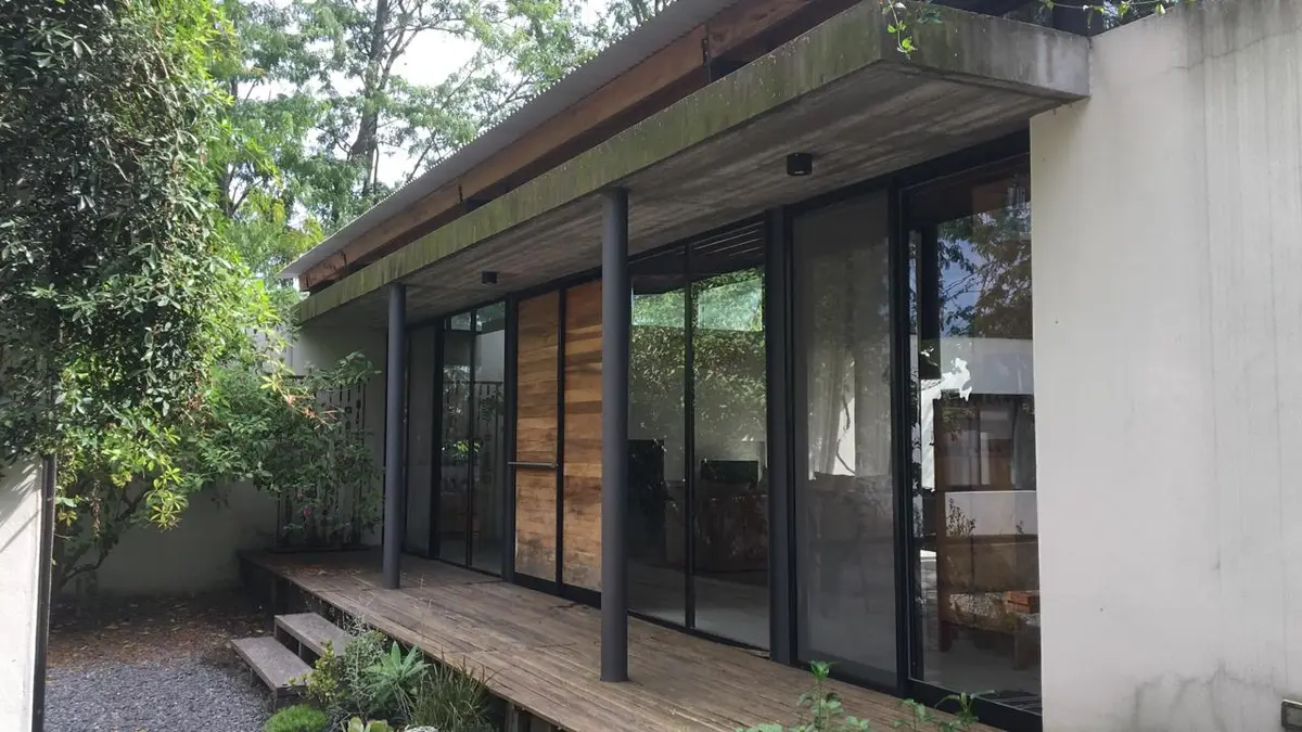 Fachada moderna de casa com deck e vegetação — projeto Casa C, por Magdalena Seal Arquitecta, em Bella Vista