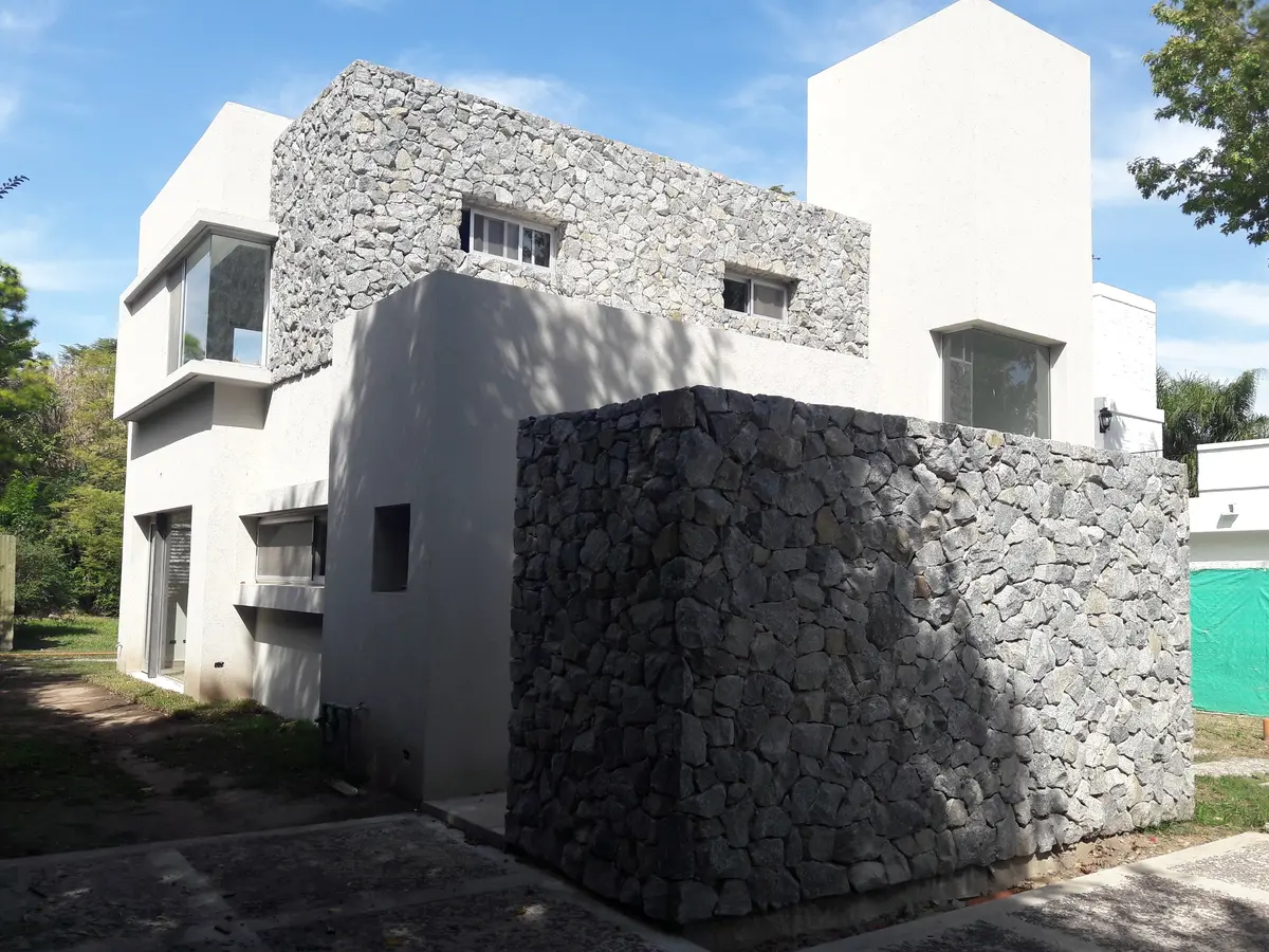Fachada moderna de piedra y hormigón — proyecto Casa L, por Magdalena Seal Arquitecta, en Bella Vista